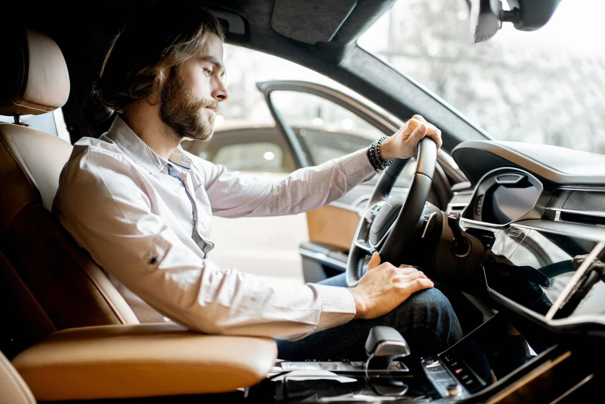 Man trying a new car at the showroom